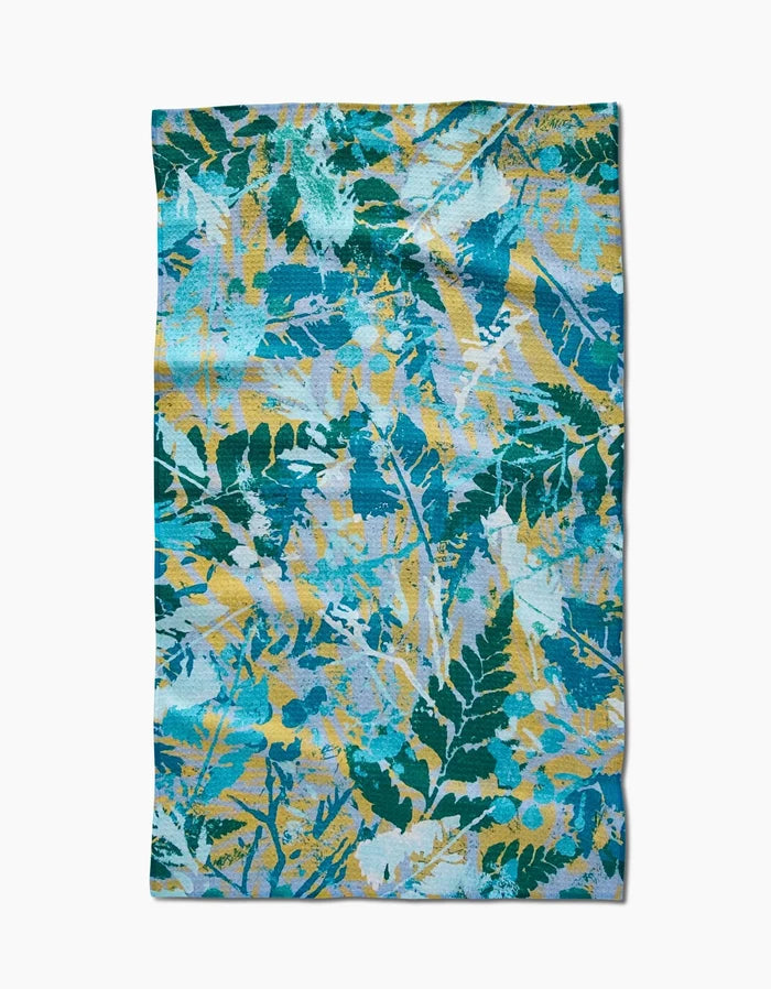 The Leafy Bush tea towel by Taryn Brennan features a vibrant blue, green, and yellow botanical pattern on premium Geoweave fabric for excellent absorbency.