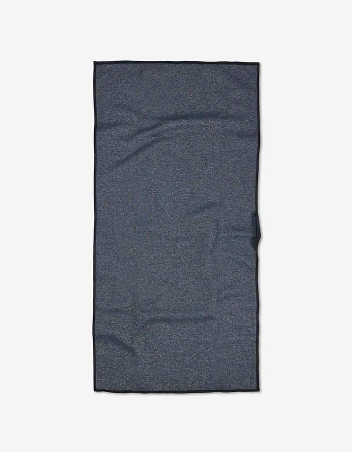 The GEOMETRY Leopard is a dark gray rectangular fitness towel with slight wrinkles, laid flat on a plain light background. Made from ultra-absorbent recycled materials for eco-friendly performance.