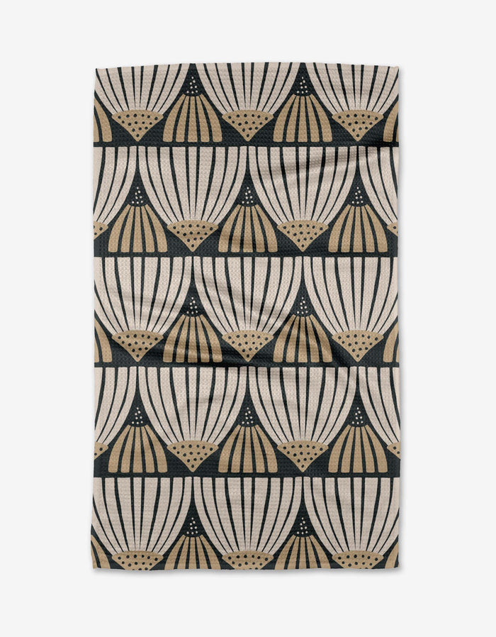 The Letitia tea towel by Amy MacCready features a cream and beige fan-like geometric pattern in black, arranged in horizontal rows. Made from recycled materials, its ultra-absorbent fabric has a slightly wrinkled look.