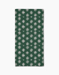 The Leyla Green napkin by Geometry features Geoweave fabric in dark green with a repeating white floral pattern, shown folded on a white background.