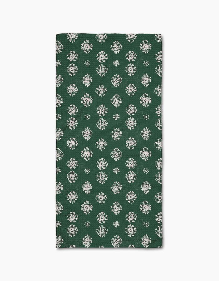 The Leyla Green napkin by Geometry features Geoweave fabric in dark green with a repeating white floral pattern, shown folded on a white background.