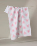 The Hufton Studio Life Line Hearts towel, featuring pink heart patterns on a quick-drying white fabric, is draped over a clothesline against a neutral background.