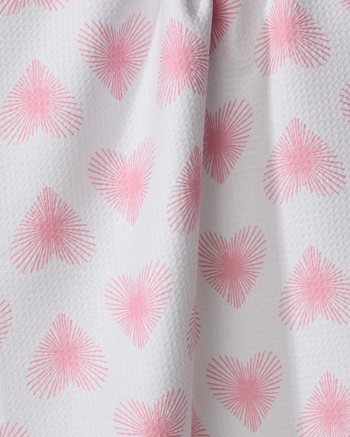 The "Life Line Hearts" towel by Hufton Studio features white textured fabric with a repeating pink heart pattern of radiating lines. Slightly gathered, this quick-drying towel is charming and practical.