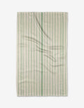 The Becki Owens Lily Stripe dish towel features a rectangular white design with ultra-absorbent, textured fabric and green vertical stripes, shown lying flat with gentle folds.
