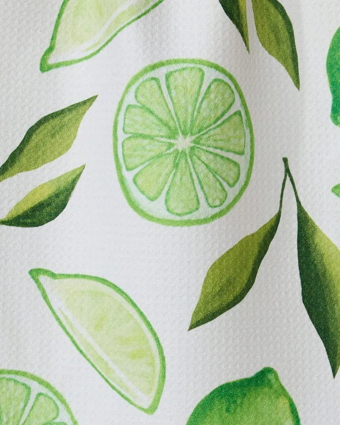 The GEOMETRY Lima bar towel features a bright, fresh pattern of green lime slices, halves, and leaves on soft Geoweave fabric made from recycled materials. The hand-drawn design appears on a white background.