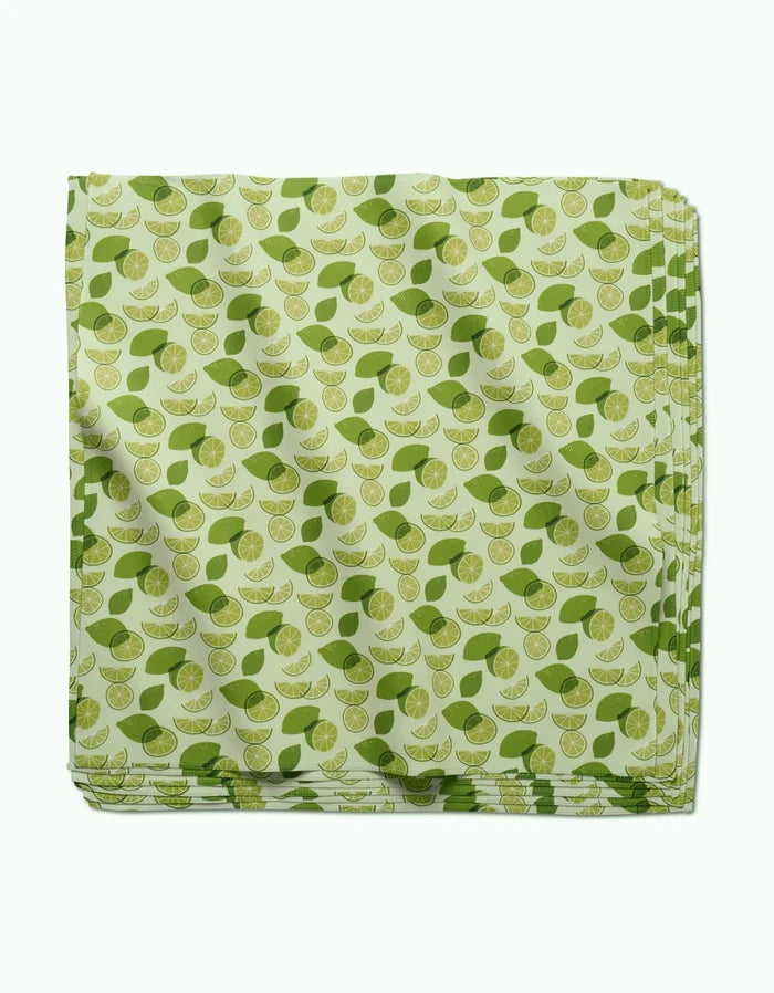 The GEOMETRY Limes napkin set features folded light green geosuede dinner napkins with a scattered lime wedge and green leaf pattern.