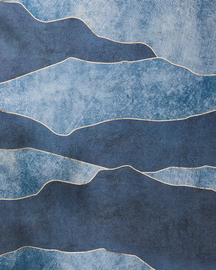The GEOMETRY "Lined With Gold" features irregular, wavy blue bands with thin white lines, resembling a slip-resistant yoga towel or flowing water, and has a rough, painterly texture.