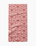 The Lined Bar Towel by Marta Harvey features red, petal-like geometric lines radiating in star-shaped patterns on a white Geoweave fabric, creating a symmetrical and stylish rectangular design.