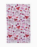 The Lip Smacking Good tea towel by Hufton Studio is a playful and romantic white cloth featuring a charming repeating pattern of pink hearts, red lips, bows, cherries, lipstick tubes, love letters, and heart-shaped glasses.