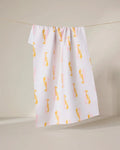 The GEOMETRY Lobster Love towel, made from recycled materials, features a white background with a yellow and pink abstract bird pattern and hangs on a clothesline against a neutral backdrop.