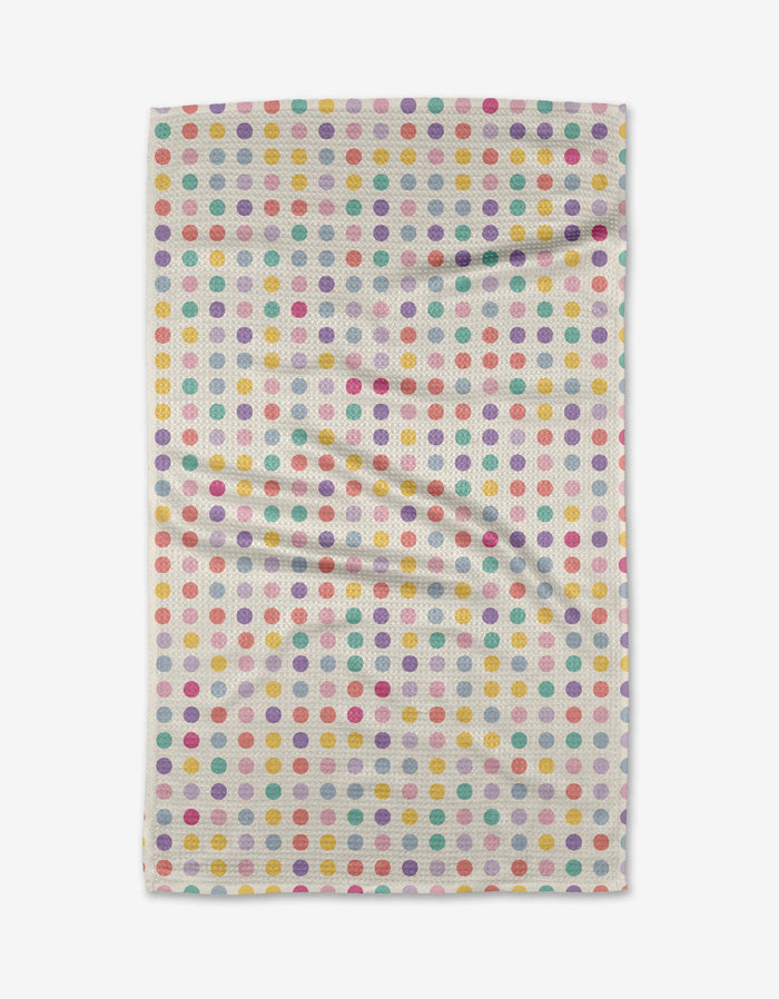 The Lots of Dots towel by Rebecca Bobko features evenly spaced, colorful polka dots on white ultra-absorbent Geoweave fabric, shown laid flat with slight wrinkles.