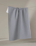 The Kailee Wright Love Notes kitchen towel, featuring black and white vertical stripes and quick-dry fabric, hangs neatly on a clothesline against a simple neutral background.