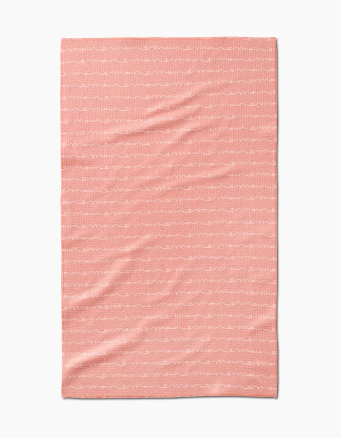 The Love of Mom blanket by Sarah Reed is a soft pink throw made from recycled materials, with thin, wavy white lines running horizontally, shown flat on a white background.