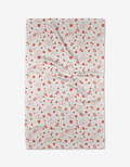 The Love Party kitchen towel by Charlie Rowan Designs is white, made from recycled materials, and features red hearts, dots, and abstract shapes. It appears slightly wrinkled and is shown against a plain white background.