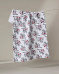 The Love Tiger by Cole Strem is a white textured cloth made from recycled materials, featuring a repeating black floral pattern with small red accents, hanging on a string against a plain light background.