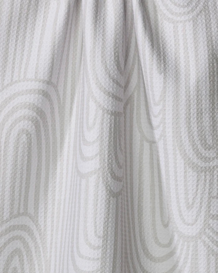 A close-up of the Lovers Arc tea towel by Hufton Studio, featuring a white textured fabric with a subtle light gray geometric pattern. The soft draping and gentle folds highlight its elegant design.