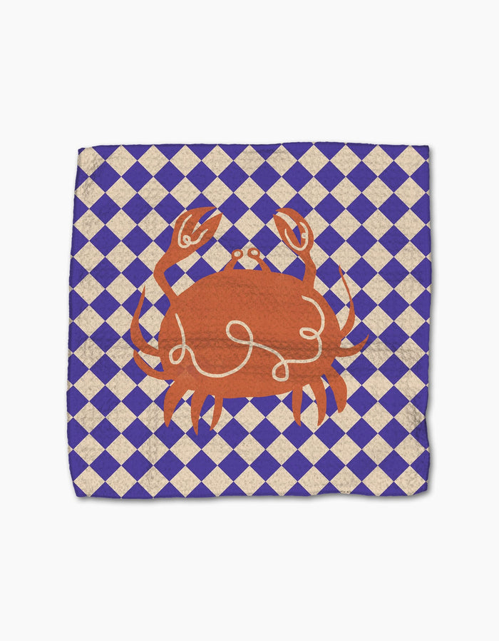 The Mar napkin by Geometry is made from recycled materials and features a blue and white diamond pattern with an orange crab illustration in the center.