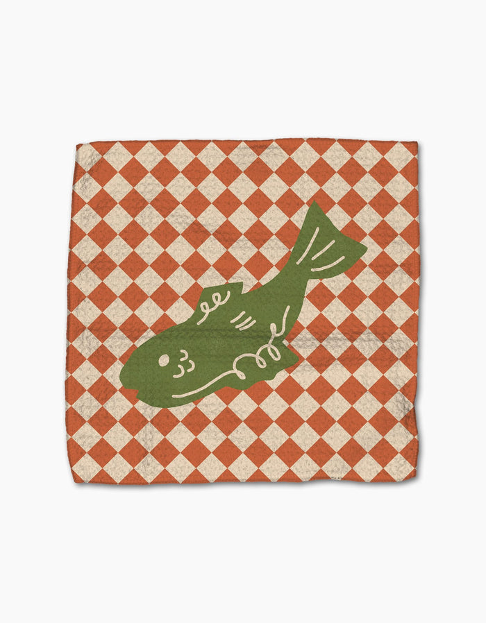 The Mar dishcloth napkin by Geometry features a green fish illustration centered on a red and white checkered, slightly distressed recycled fabric.