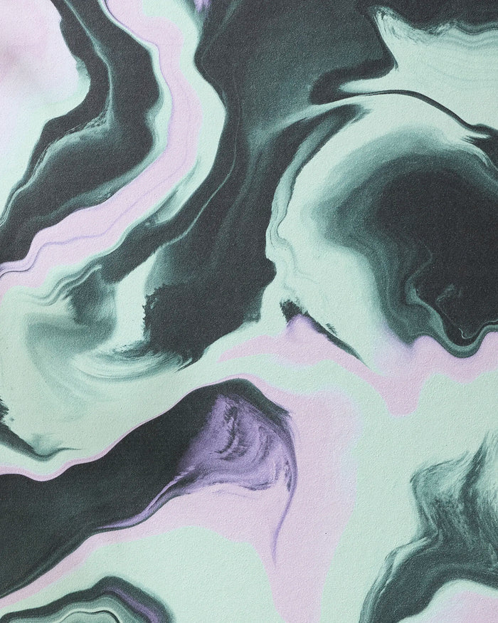 Swirling black, white, and lavender patterns create a marble effect on the GEOMETRY Marble yoga towel, blending smooth colors for a calming, elegant vibe inspired by liquid art and premium recycled materials.
