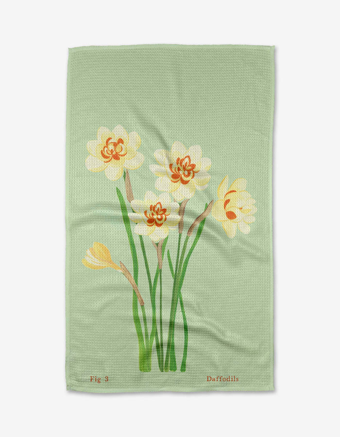 The March Daffodils tea towel by Linda Fox features yellow and orange daffodils with green stems on Geoweave fabric. “Fig 3” and “Daffodils” are printed along the bottom edge.