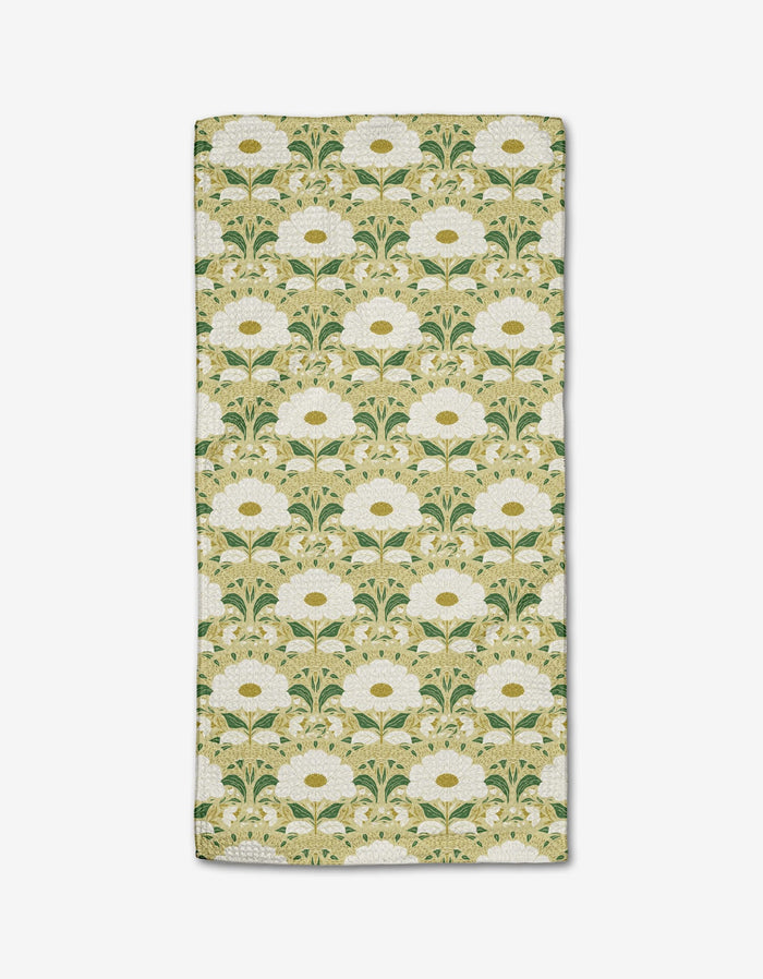The Danelys Sidron Margarita bar towel is rectangular, made from ultra-absorbent Geoweave fabric, and features white flowers with yellow centers and green leaves on a light beige background in a vintage Art Nouveau style.