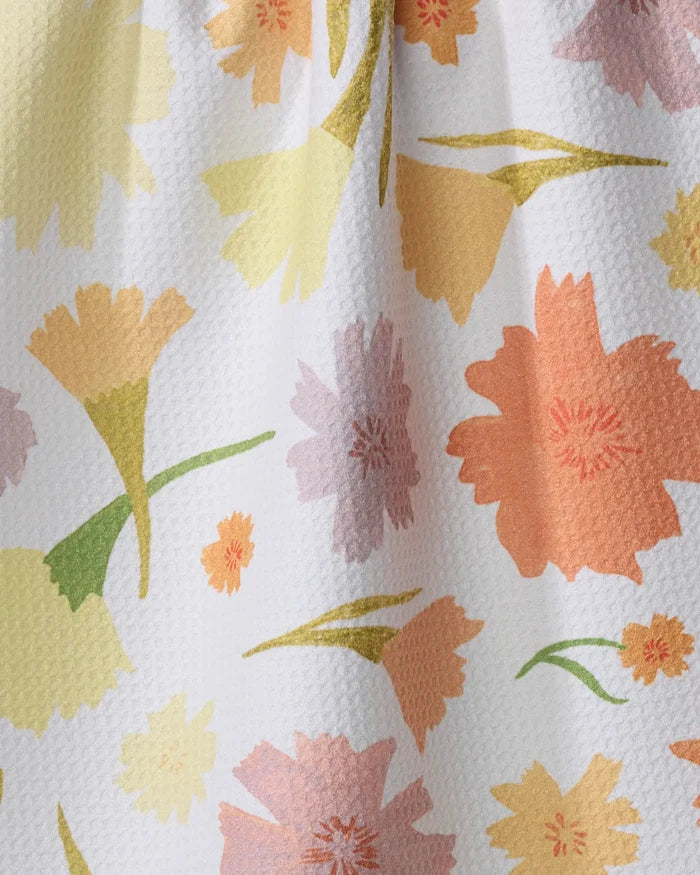 A close-up of Elana Gabrielle’s Marigold Flowers kitchen towel, ultra-absorbent with a textured surface and a vibrant floral pattern in yellow, orange, pink, and green on a white background.