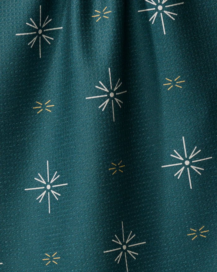 A close-up of Marine Navigation by Twig + Spark shows dark teal Geoweave fabric made from recycled materials, featuring a subtle texture and evenly spaced white and gold starburst designs.