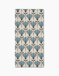 The Martine rug by Amy MacCready is a rectangular beige piece with evenly spaced rows of stylized blue flowers and black stems, crafted from recycled materials for an eco-friendly touch.