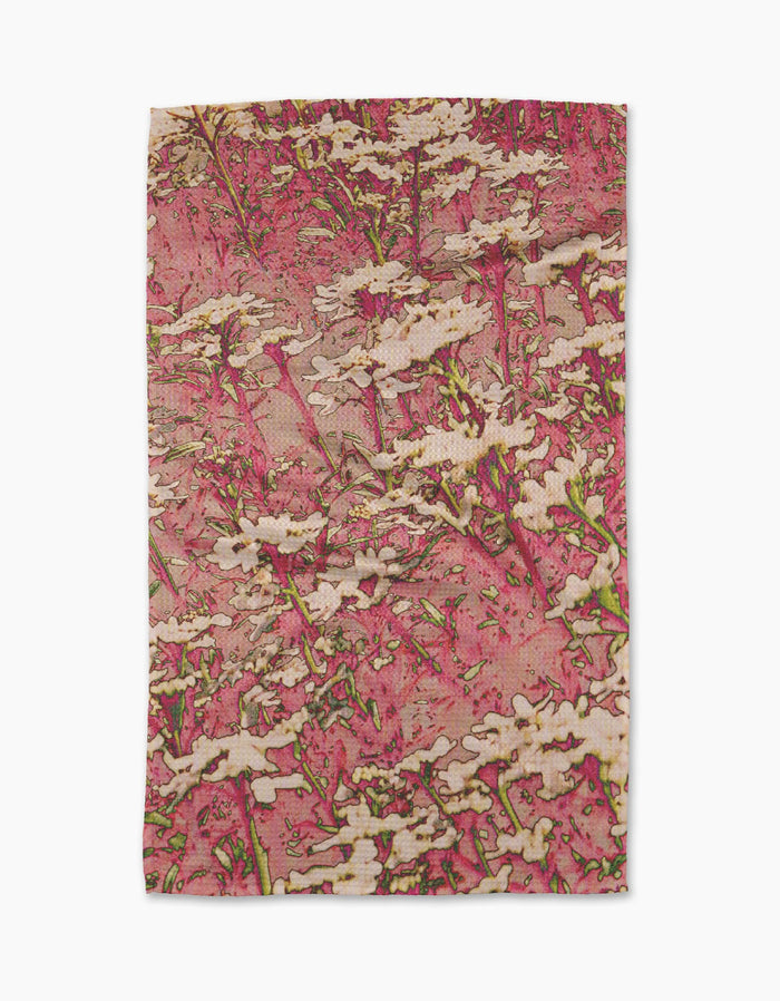 The Maximist Floral tea towel by Geometry features an abstract floral design with white flowers and green stems on a textured pink background, and is crafted from recycled materials.