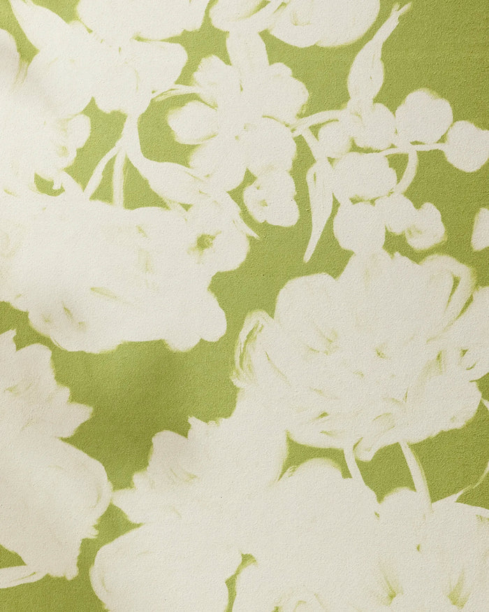 A close-up of GEOMETRY's Meadow Mist, a green recycled yoga towel with white floral patterns in soft, abstract outlines of flowers and leaves.
