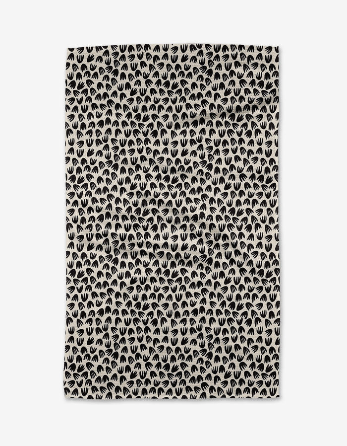 The Kayla Ann Microbloom is a beige rectangular tea towel with a repeating pattern of small black stylized handprints closely arranged across its ultra-absorbent surface.