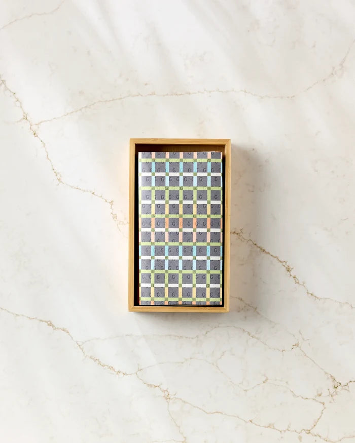 The Mindfulnice "Mindful Medley" box of assorted square chocolates is displayed in a colorful grid on a veined marble surface beside a stack of eco-friendly kitchen towels.