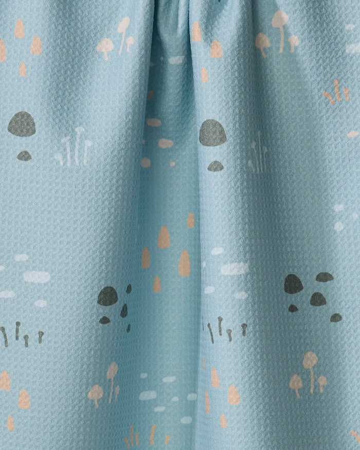 The Amberleigh Adoff Mini Shroom Sprouts towel is a light blue, textured kitchen towel with small gray, beige, and peach mushrooms and plants. Made from recycled materials for an eco-friendly touch.