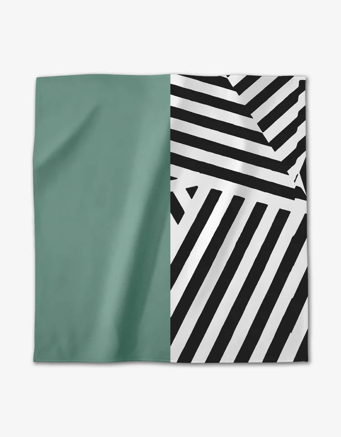 The GEOMETRY Mint Stripes Dinner Napkin features Geosuede fabric with a solid teal left half and bold black-and-white diagonal stripes forming geometric patterns on the right.