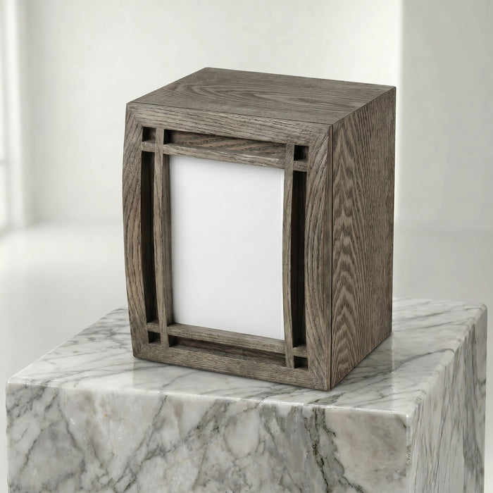 Wooden curbed portrait urn on a marble surface with a white background