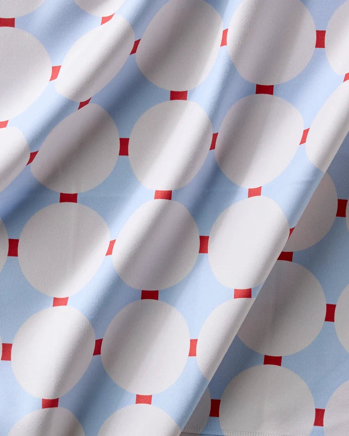 Mist Blue Oasis by Happy Hemera features a reusable dinner napkin fabric with large white circles on a light blue background, accented by small red squares between the circles and soft visible folds.