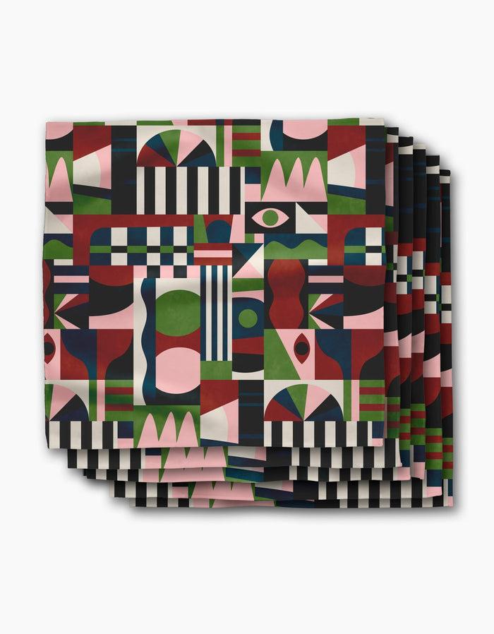 The Modern Bauhaus Mood dinner napkins by Claire Iglesias showcase a colorful geometric pattern in red, green, pink, black, and white on soft Geosuede fabric for a bold, abstract look.