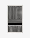 The Modern Form towel by GEOMETRY features Geoweave technology with black and white vertical stripes on the top and bottom, and abstract horizontal lines of varying thicknesses and shades in the middle for a modern look.