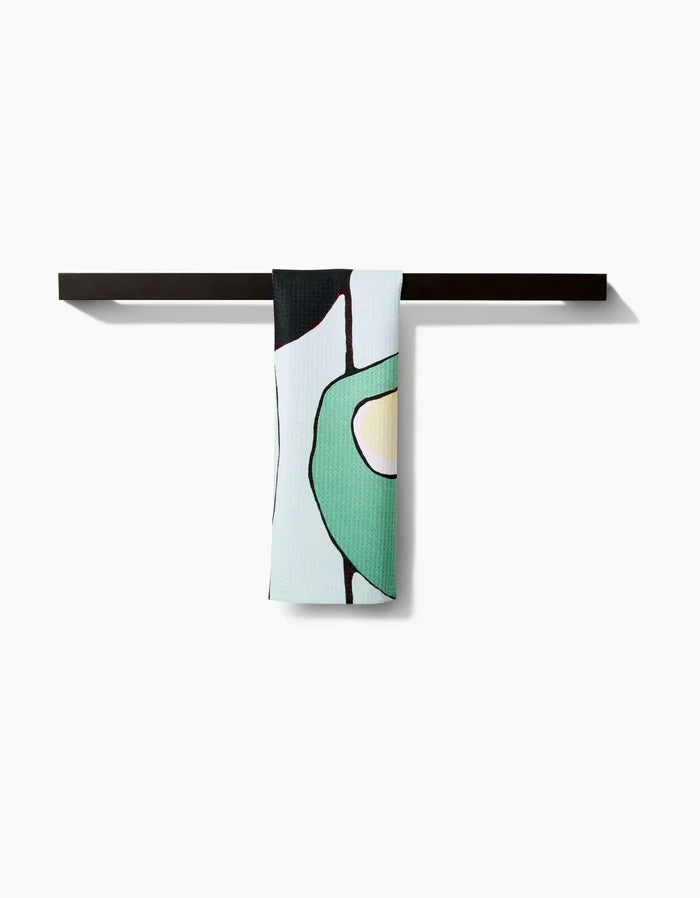 The Rachel Austin Modern Poppy bar towel, made from premium Geoweave fabric, showcases a minimalist abstract green and yellow design draped over a sleek black bar on a white background.