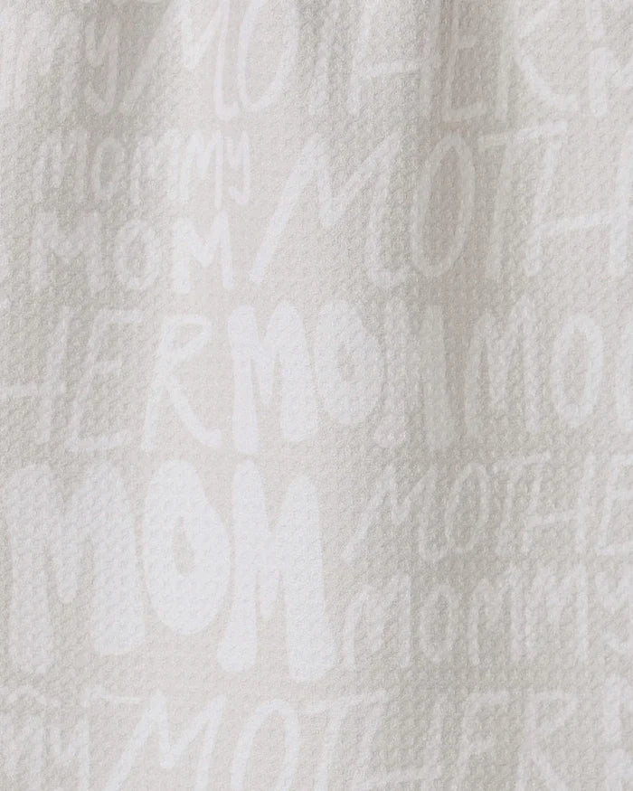 The GEOMETRY Mom bar towel is crafted from recycled white textured fabric, featuring “MOM,” “MOTHER,” and “MOMMY” in varied fonts and sizes printed subtly across its surface.