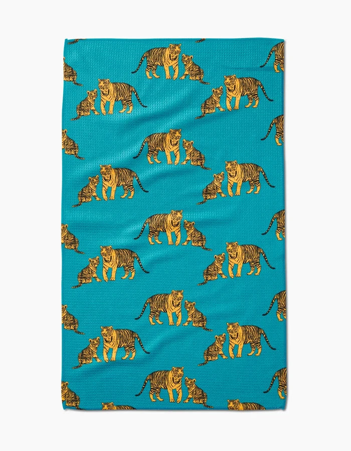 The Mommy and Me tea towel by Sarah Holden features a turquoise Geoweave fabric with a repeating pattern of orange, black, and white adult tigers and playful cubs.