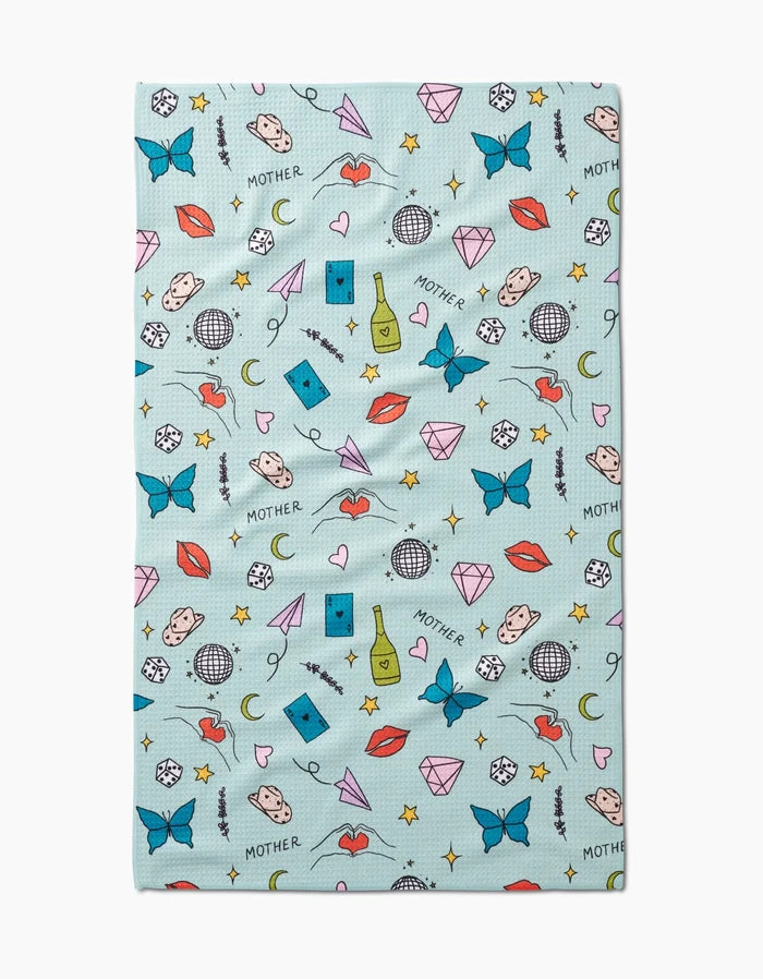 Mother by Sarah Holden is a light blue cloth crafted from recycled materials, featuring colorful illustrations like butterflies, diamonds, red lips, dice, hearts, disco balls, faces, wine bottles, stars, and the word MOTHER.