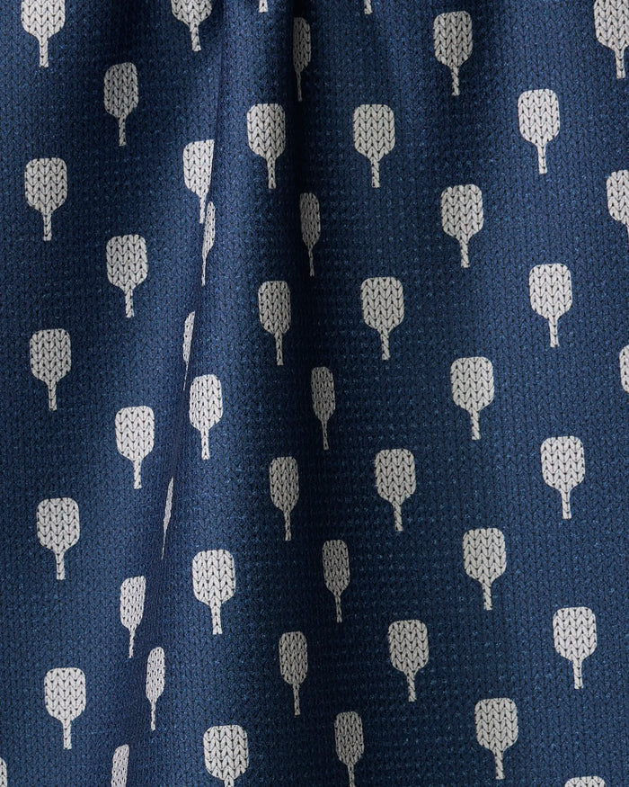 Close-up of The Modern Dad's Mr. Pickler tea towel in blue, featuring a repeating pattern of small white tree-like shapes. Made from recycled materials, the fabric has subtle folds and a textured surface.