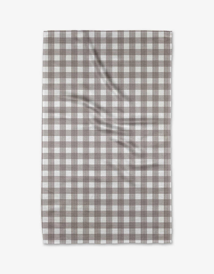 The Buy Guide’s Multi Gingham - Chocolate tea towel, made from Geoweave fabric in a brown and white checkered pattern, is shown laid flat with slight wrinkles visible.