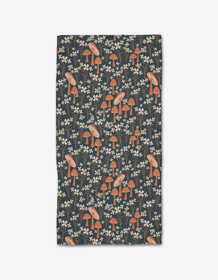Mushroom Grove by Charlie Rowan Designs is a rectangular bar towel with orange and white mushrooms and small white flowers on a dark background, made from Geoweave™ fabric for excellent absorbency and durability.