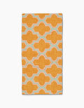 The Mustard Ogee by Pascale Dilger is a rectangular, ultra-absorbent towel featuring a bold orange geometric pattern with interconnected shapes outlined in light blue and white on a plain white background.