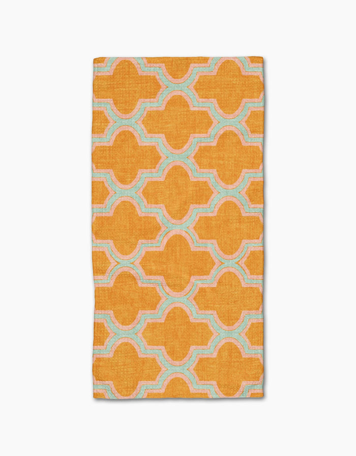 The Mustard Ogee by Pascale Dilger is a rectangular, ultra-absorbent towel featuring a bold orange geometric pattern with interconnected shapes outlined in light blue and white on a plain white background.