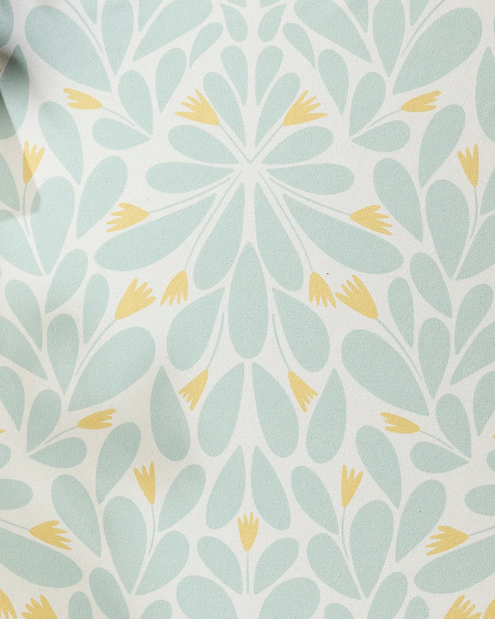 The Mustard Pinwheel yoga towel by Rebecca Woolbright features a light blue and yellow floral pinwheel design on a non-slip surface, adding elegance and decorative flair to your practice.