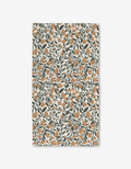 The Naomi bath towel by Charlie Rowan Designs features an orange floral and dark green leaf pattern on cream. Made with Geoweave technology, it offers a vintage botanical look plus modern absorbency and function.
