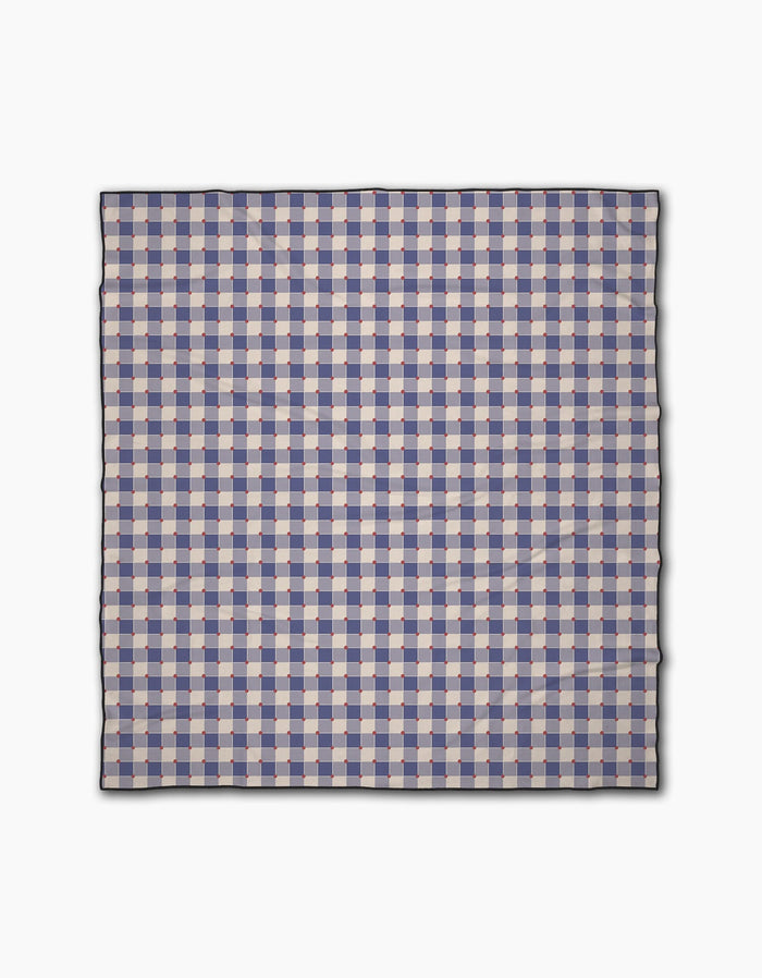 The Geometry Nautical Gingham is a square beach blanket with a blue, white, and light pink checkered pattern, thin black border, and made of quick-drying recycled materials, shown flat on a white background.